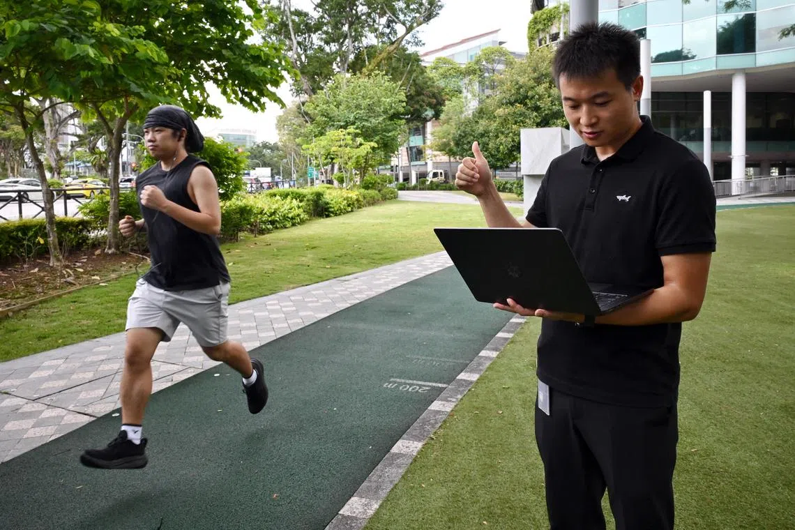 Dr Ma Dong, Assistant Professor of Computer Science from the School of Computing and Information Systems at SMU (right) with Hu Changshuo, a first-year PhD student  testing the customised earbud prototype that helps runners run more efficiently and safely. It monitors four breathing modes used during running, and the gait of  runners.