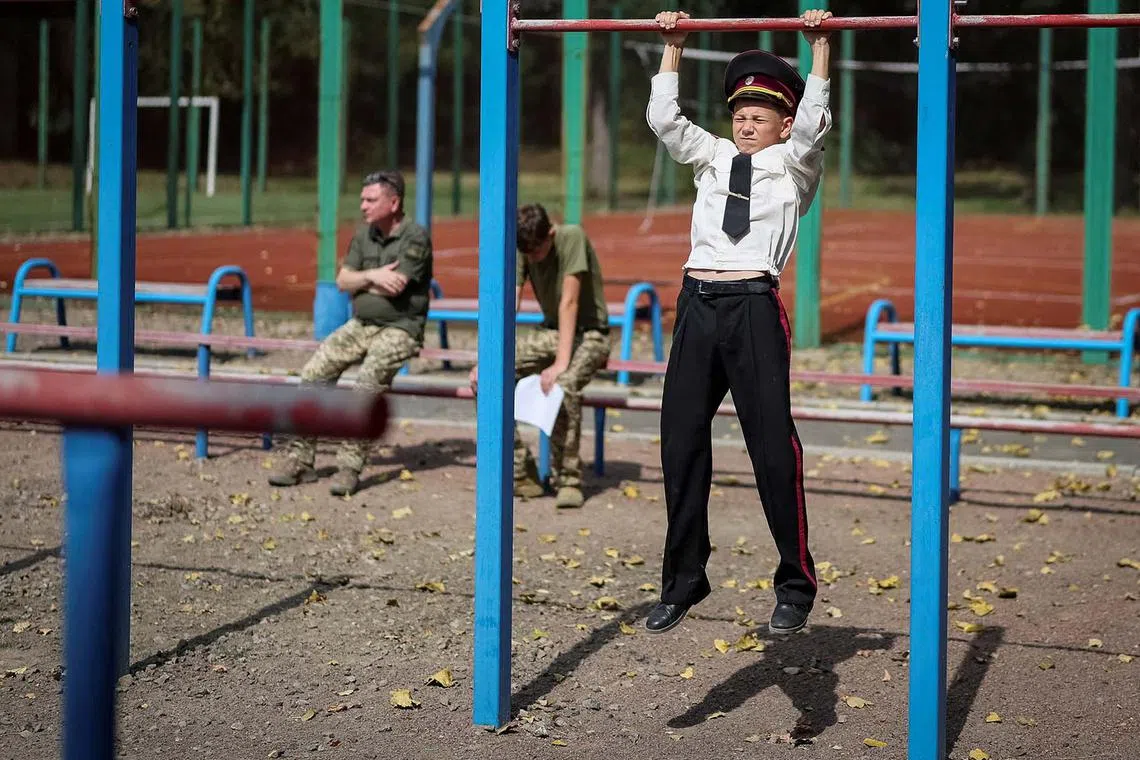 A young military cadet doing pull-ups after a ceremony to mark the start of the new school year, amid Russia's attack on Ukraine, in Kyiv, Ukraine, Sept 1, 2025. 