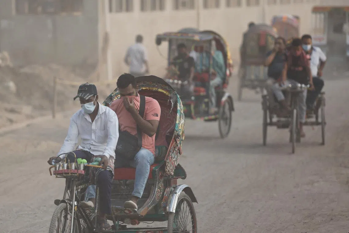 People move through a dusty road, as air quality reduces ahead of the winter in Dhaka, Bangladesh, November 4, 2024. REUTERS/Mohammad Ponir Hossain