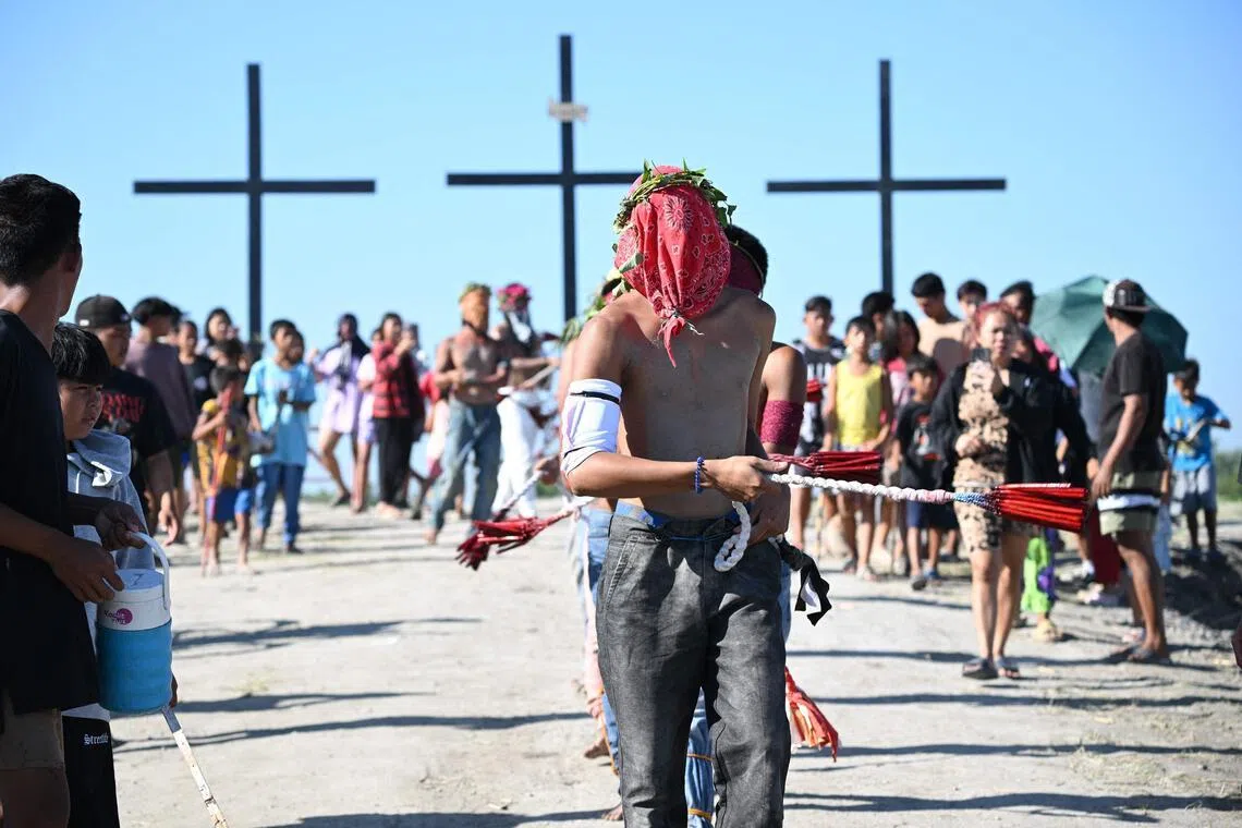 Penitents flagellate themselves as they walk to a mound with crosses prior to the annual crucifixion during the observance of Lent in the village of Cutud in San Fernando City.