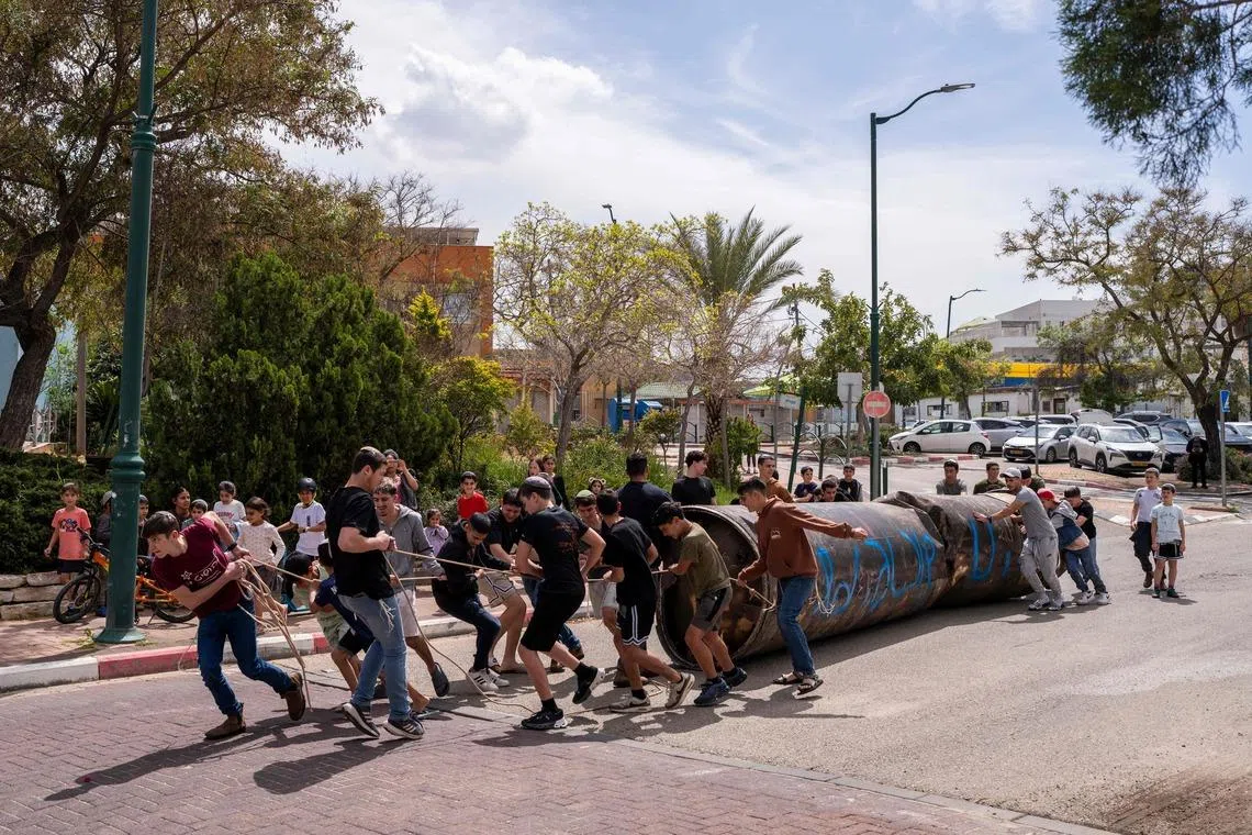 Children moving part of an Iranian missile remnant that fell in a school courtyard in the Israeli settlement of Peduel, in the occupied West Bank on March 23. Iran has been firing barrages of missiles at Israel in response to the bombing campaign by Israel and the United States that started on Feb 28, following the killing of the country's supreme leader. 