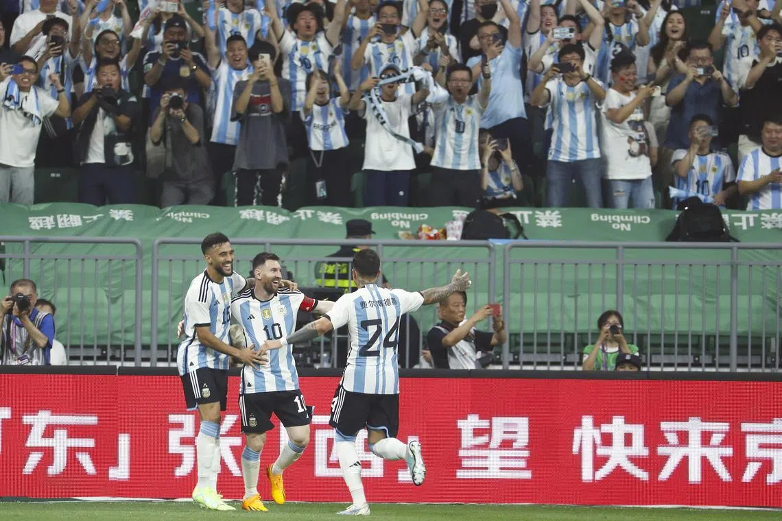 Argentina's Lionel Messi of Argentina celebrates with teammates after scoring the first goal against Australia.
