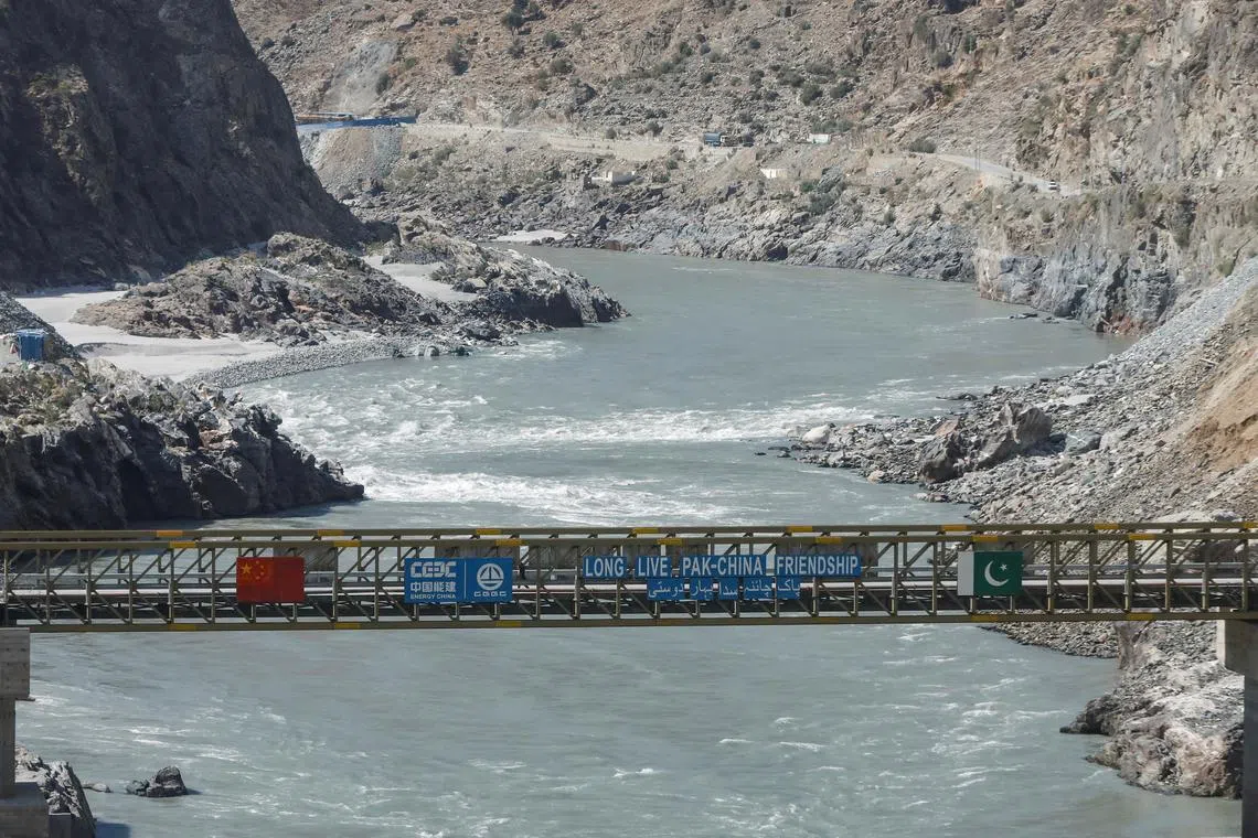 FILE PHOTO: View of a bridge with China and Pakistan's flag over the River Indus, at the site of Dasu Dam or Dasu Hydropower Project, in Kohistan district Kyber Pakhtunkhwa province, near Dasu, Pakistan October 6, 2023. REUTERS/ Akhtar Soomro/File Photo