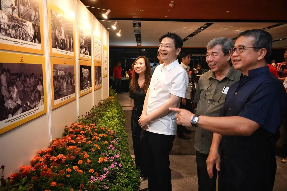 PM Lawrence Wong and Edwin Tong, deputy chairman of PA, Minister of Culture, Community and Youth, looking at the photo exhibition of the Community Clubs from yesteryears at the 60th anniversary celebrations of the Community Club Management Committees (CCMCs) on Monday, 4 November 2024