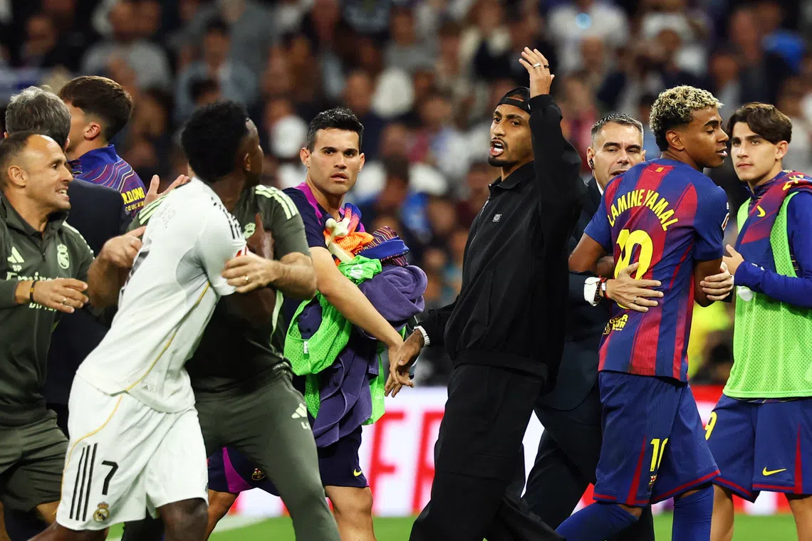 Soccer Football - LaLiga - Real Madrid v FC Barcelona - Santiago Bernabeu, Madrid, Spain - October 26, 2025 FC Barcelona's Lamine Yamal and Real Madrid's Vinicius Junior clash after the match REUTERS/Susana Vera