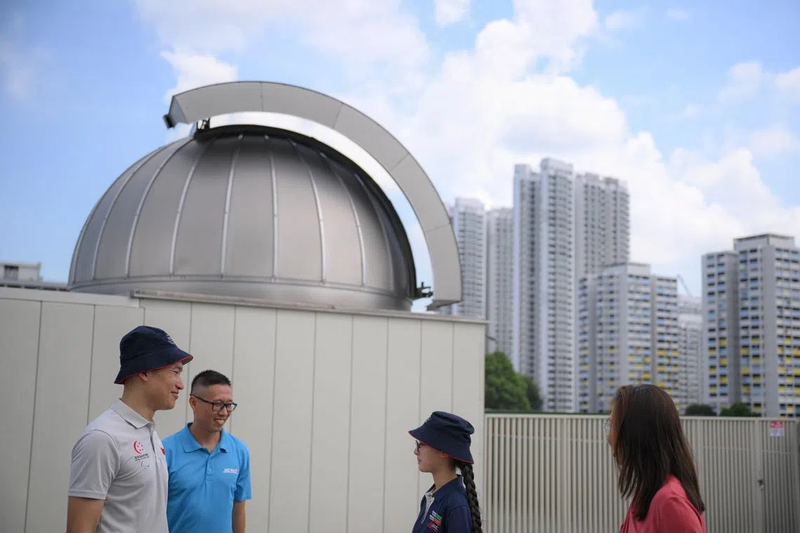 Senior Minister of State for Education David Neo (far left) and SST principal Nick Chan (in blue) outside the Galileo Observatory on April 20.