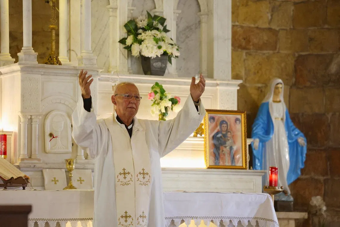 FILE PHOTO: Reverend Najib Amil gestures during a mass at St. George Church in the Christian town of Rmeich, near the Israel-Lebanon border, Lebanon November 12, 2025. REUTERS/Aziz Taher/File Photo