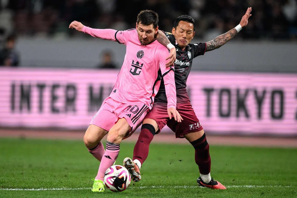 Vissel Kobe midfielder Yosuke Ideguchi tussling with Inter Miami forward Lionel Messi in a friendly match in Tokyo on Feb 7.