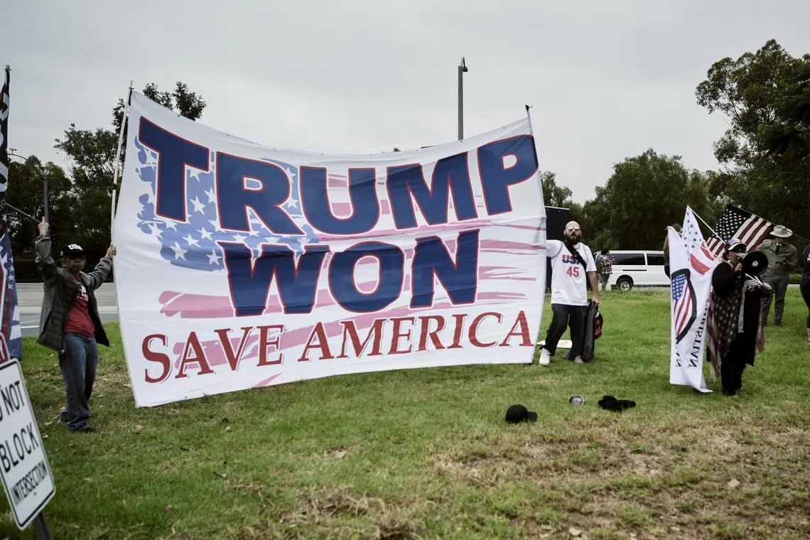 FILE — Pro-Trump protestors react as the motorcade carrying President Joe Biden leaves from an event at Irvine Valley College in Irvine, Calif., on Oct. 14, 2022. Trump’s push to overturn his 2020 loss was roundly rejected by courts, and now dozens of lawyers who argued the cases are working for Republican campaigns and groups. (T.J. Kirkpatrick/The New York Times)
