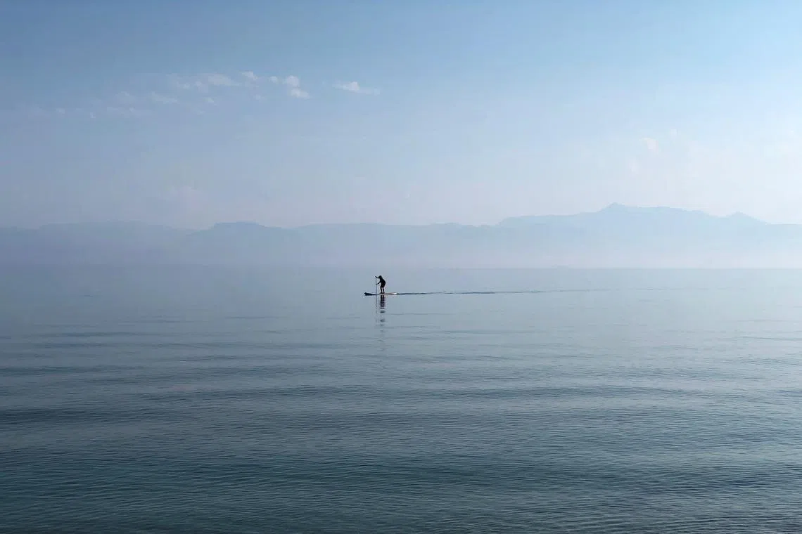 FILE PHOTO: A man paddles in the waters of the Ionian Sea near Sidari settlement on the island of Corfu, Greece July 26, 2019. REUTERS/Vasily Fedosenko/File Photo