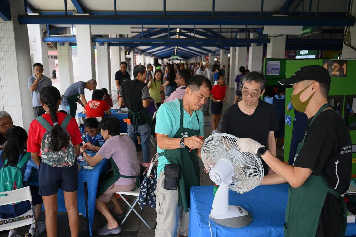 Mr Richard Lee (second from right) learning from Repair Kopitiam volunteers Edmund Ho (right) and Wong Tuan Wah at the repair clinic on Oct 26.