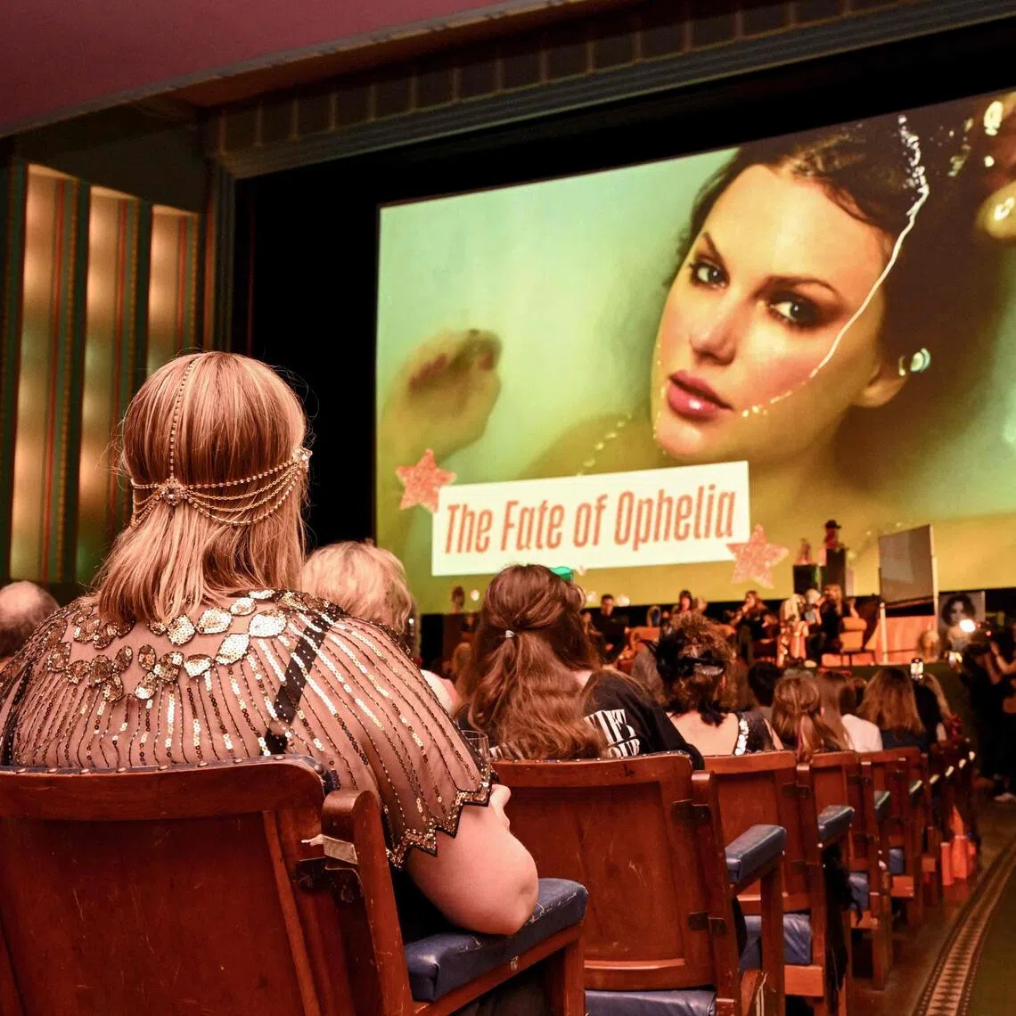 Taylor Swift fans listen to a song during a listening event for her new album The Life Of A Showgirl at the Astor Theatre in Melbourne on Oct 3.