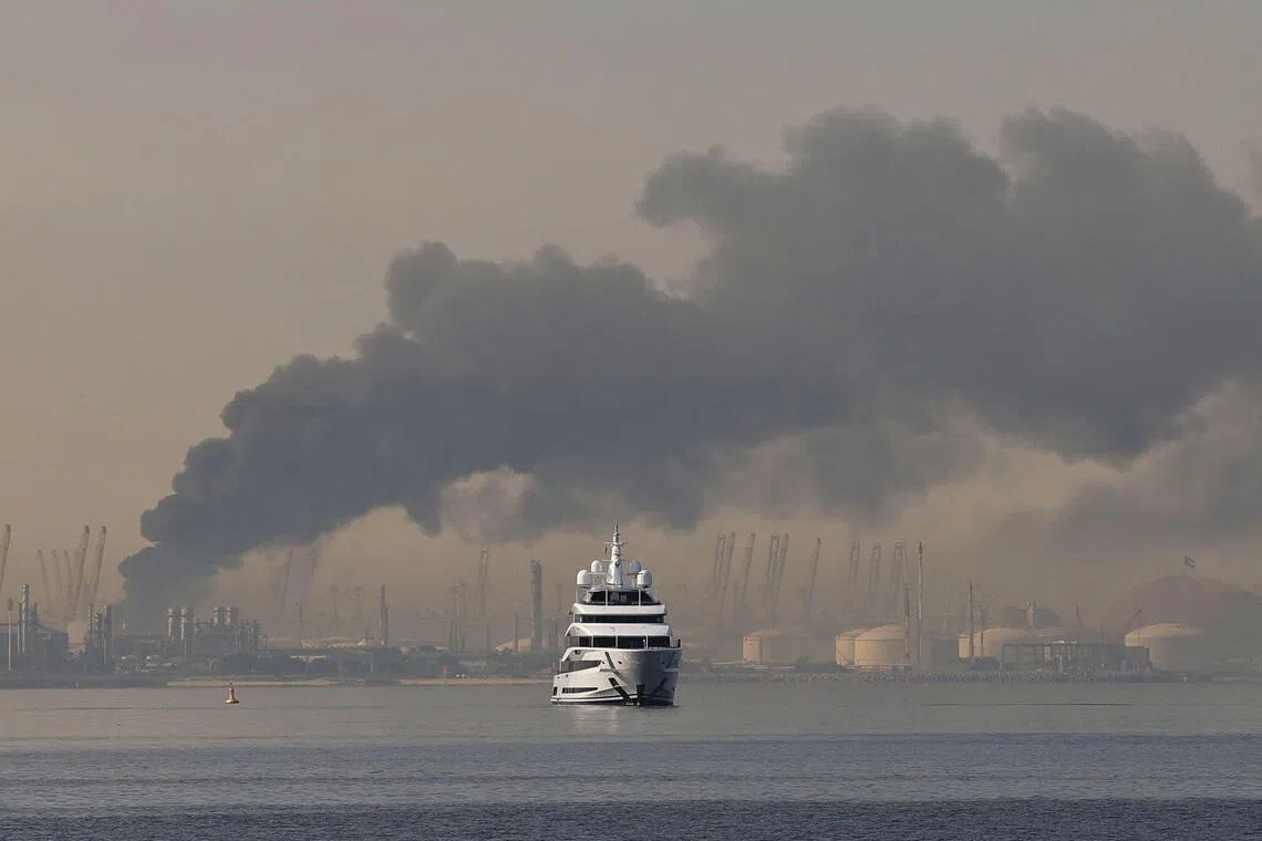 A yacht sails past a plume of smoke rising from the port of Jebel Ali following a reported Iranian strike in Dubai on March 1.