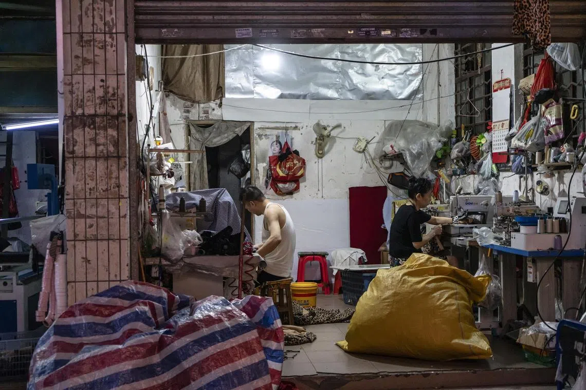 Workers at a small garment factory in Guangzhou, China, July 29, 2025. A glut of finished garments has driven down prices, adding to the challenges in GuangzhouÕs factory district. (Qilai Shen/The New York Times)