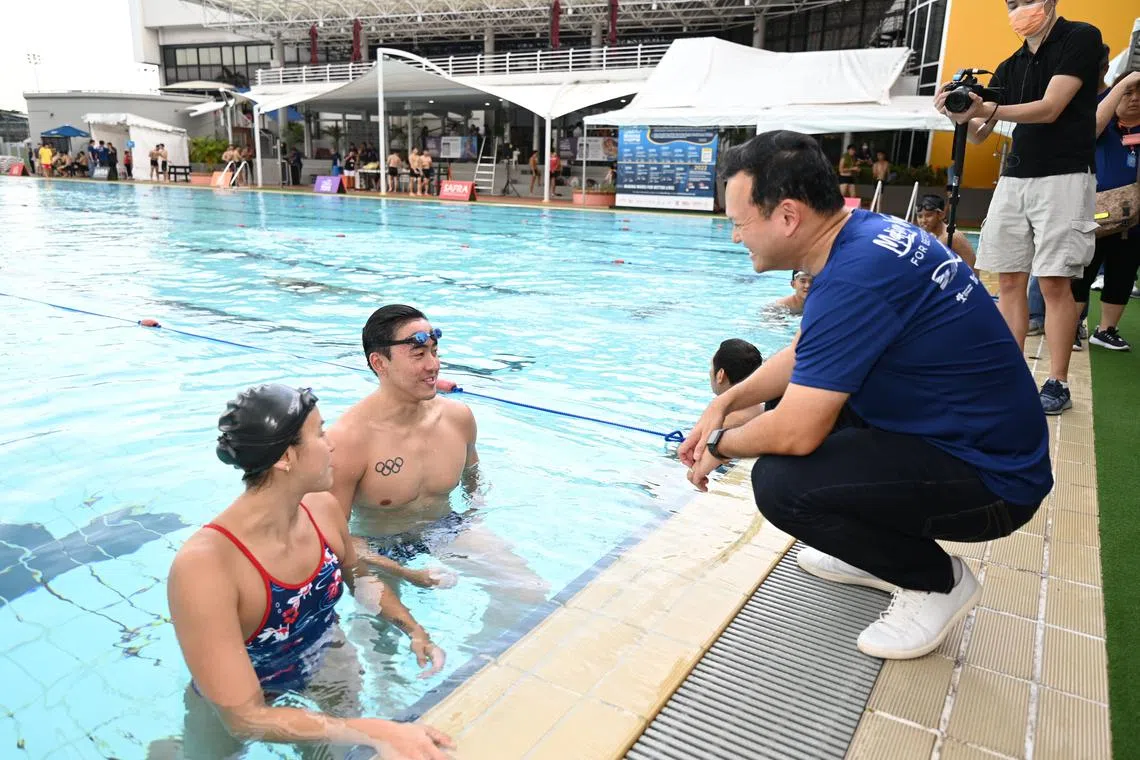 Senior Minister of State for Defence and Safra president Zaqy Mohamad interacting with national swimmers Quah Zheng Wen and Quah Ting Wen during the Safra Swim for Hope 2022.