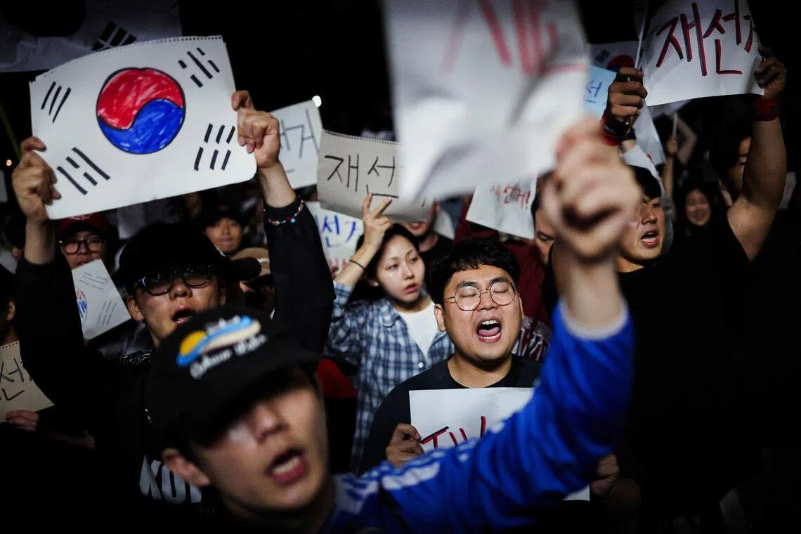 Demonstrators holding signs reading "Rerun election", outside a vote-counting centre in Seoul on June 6.