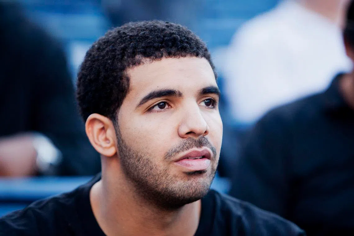 FILE PHOTO: Canadian rapper Drake watches the third round match of Serena WIlliams of the U.S. and Zheng Jie of China during the Rogers Cup women's tennis tournament in Toronto August 11, 2011.    REUTERS/Mark Blinch/File Photo