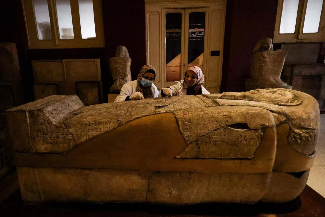 Archaeologists examine a sarcophagus inside the Egyptian Museum in Cairo, Egypt, Dec 12, 2022. 