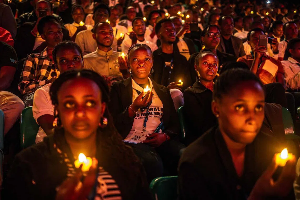 Young Rwandans holding flameless candles while taking part in a vigil during the 30th anniversary of the 1994 Rwandan genocide at the BK Arena in Kigali on April 7, 2024. 