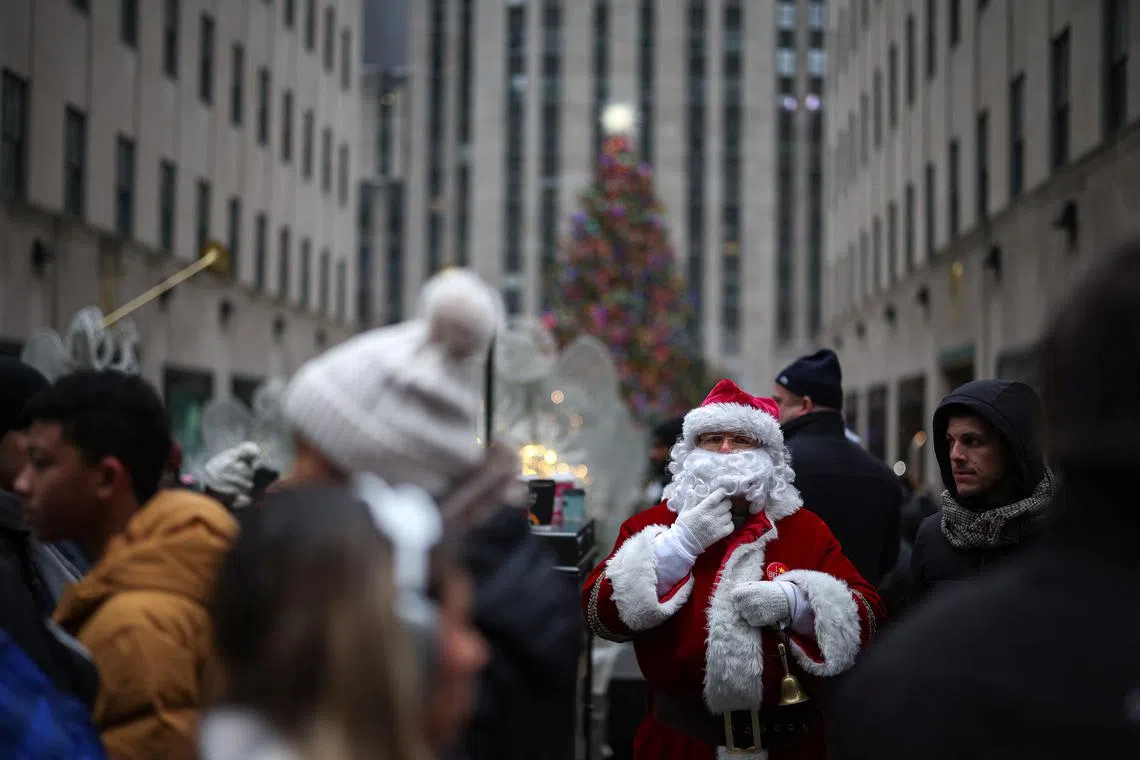 A man dressed as Santa stands in front of the Rockefeller Center Christmas Tree in Manhattan in New York City, U.S., December 24, 2024. REUTERS/Marko Djurica