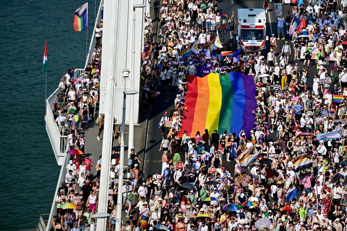 People cross Elizabeth Bridge with a rainbow flag as they attend the Budapest Pride March in Budapest, Hungary, June 27, 2026. REUTERS/Marton Monus