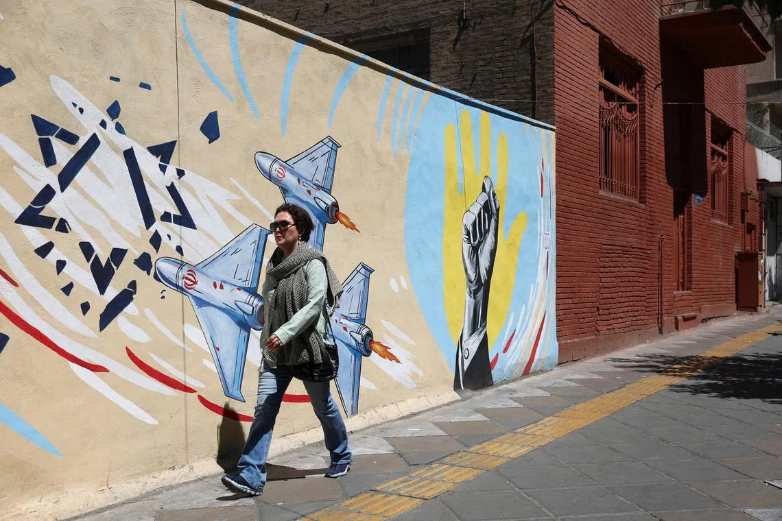 An Iranian woman walks next to an anti-Israeli mural on a street in Tehran, Iran, May 26, 2026. Majid Asgaripour/WANA (West Asia News Agency) via REUTERS