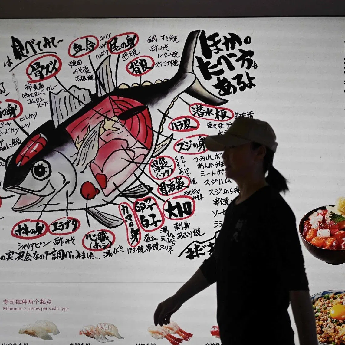 A woman walks past a Japanese restaurant in Beijing.