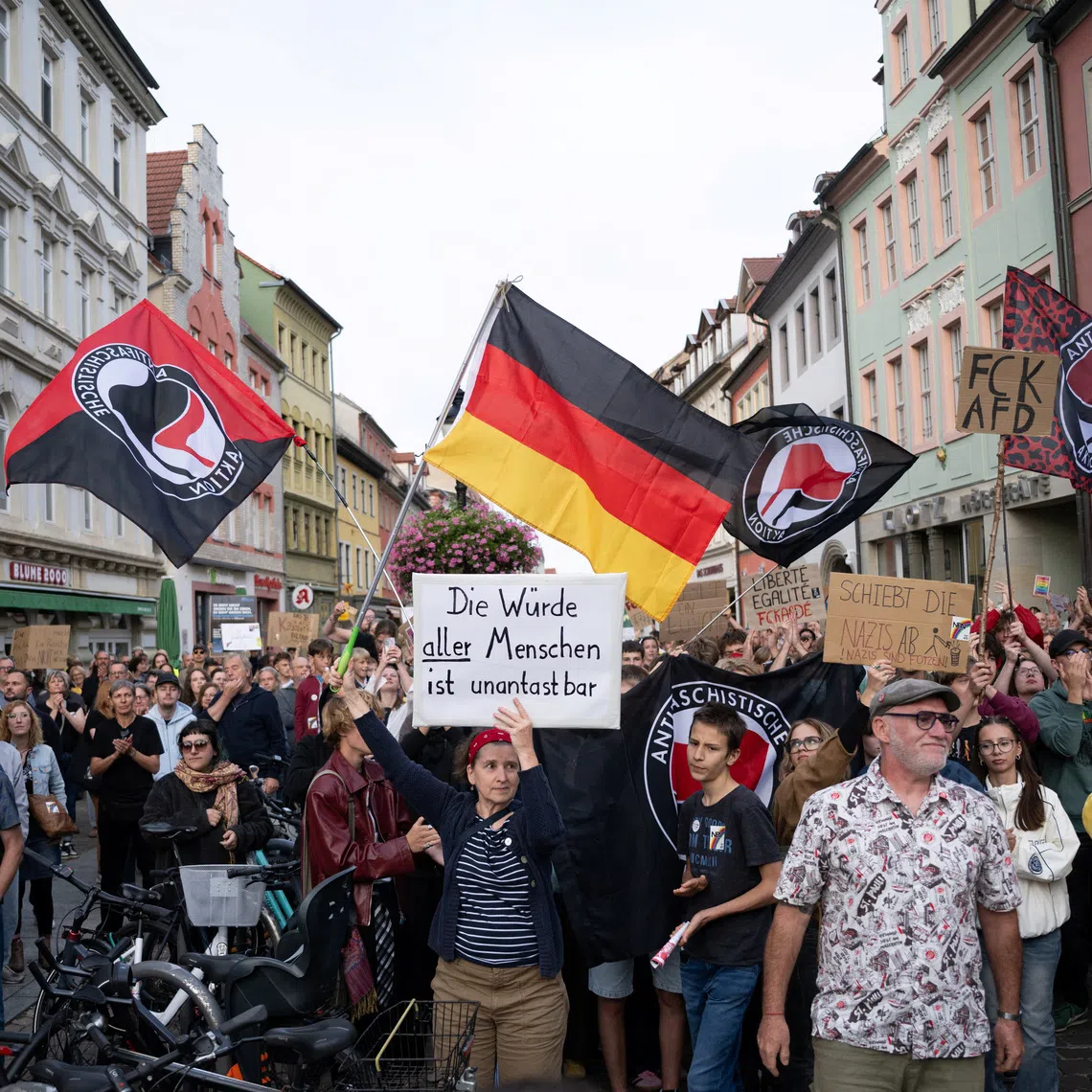 People hold posters during a counter-protest at a campaign rally of the far-right Alternative for Germany (AfD) in Naumburg, a former Soviet garrison town, in Saxony-Anhalt, Germany, ahead of the state election on September 6, where the party hopes to secure enough votes to lead a state government for the first time in Germany, August 24, 2026. REUTERS/Annegret Hilse