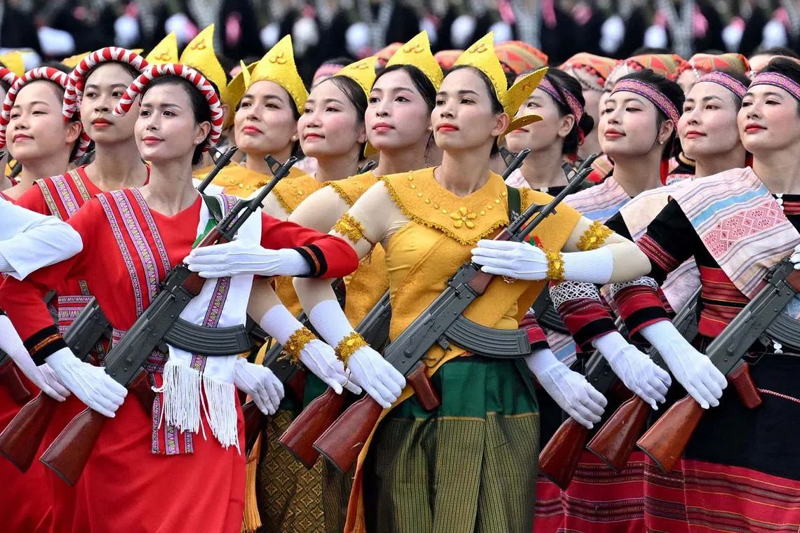 Women wearing Vietnamese national costumes while taking part in a National Day parade rehearsal in Hanoi on Aug 13, 2025, ahead of Vietnam's 80th National Day on Sept 2. 