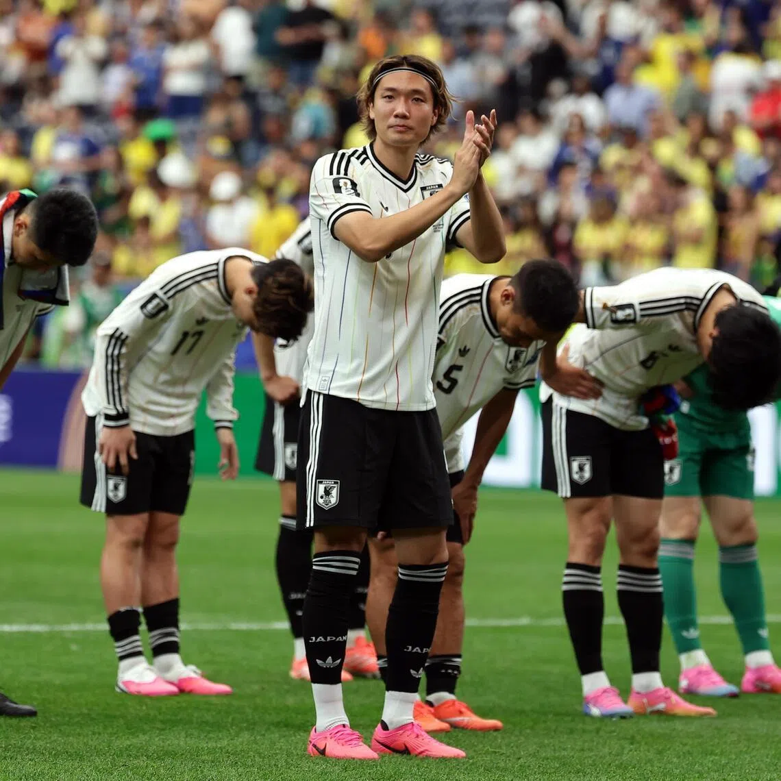 Japan captain Kou Itakura and teammates bowing to their fans after losing 2-1 to Brazil in the World Cup round of 32 on June 29.