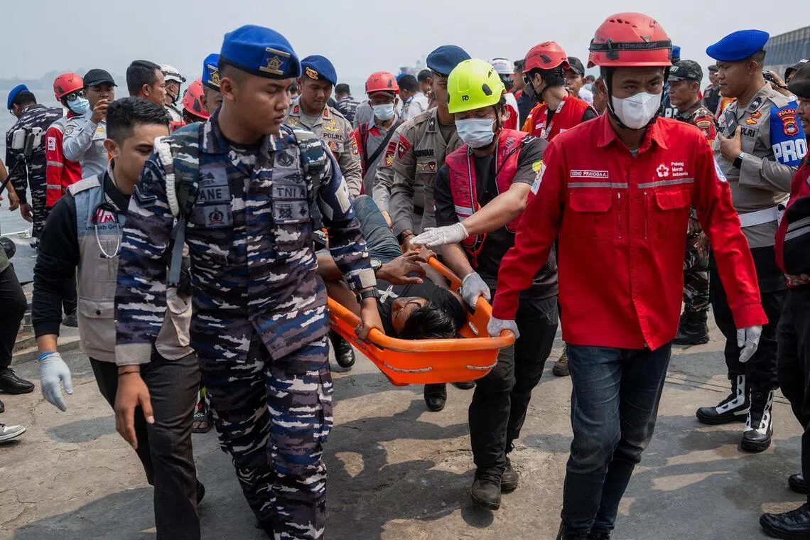 Rescuers carry a passenger of the Virgo Transport 8 ferry that capsized in Indonesia’s Java Sea on Sept 13.