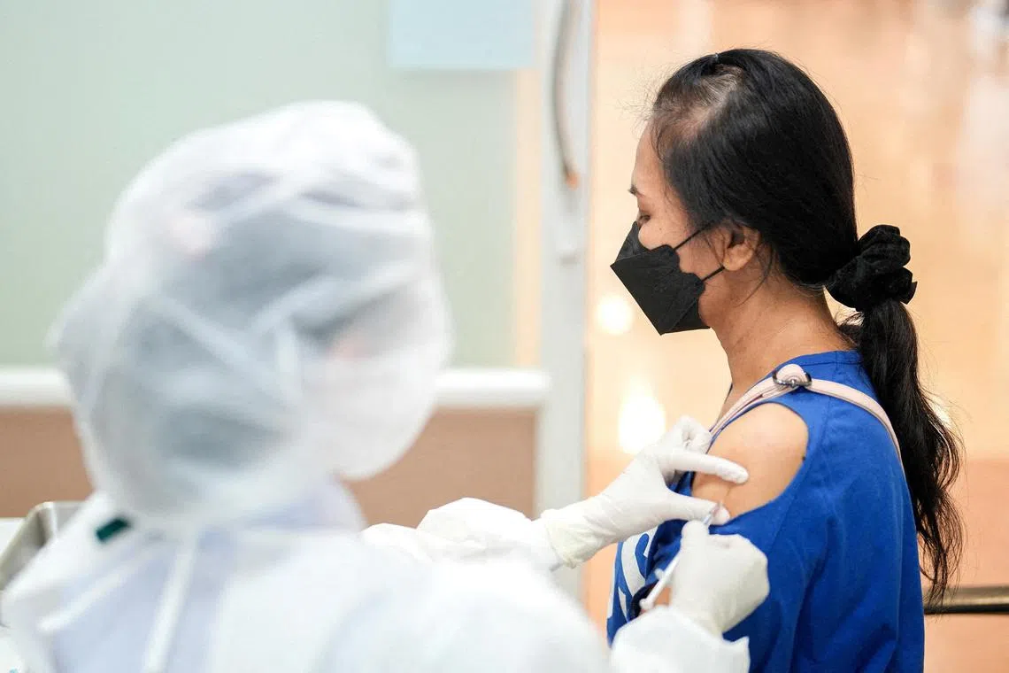 A woman receives a booster dose of Pfizer-BioNTech vaccine against coronavirus, in Bangkok, Thailand