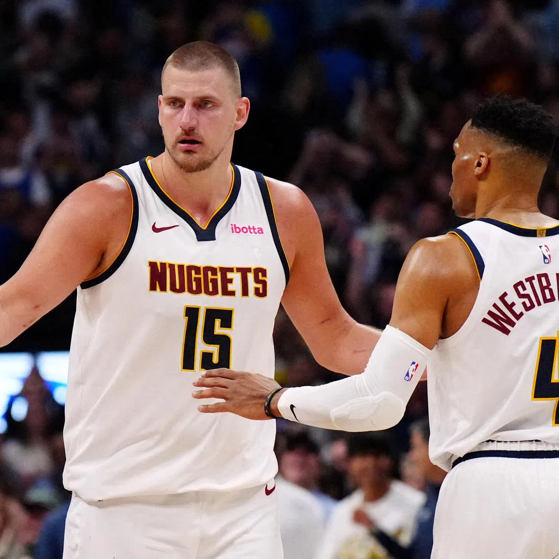Denver Nuggets centre Nikola Jokic and guard Russell Westbrook celebrate defeating the Memphis Grizzlies at Ball Arena on April 11.
