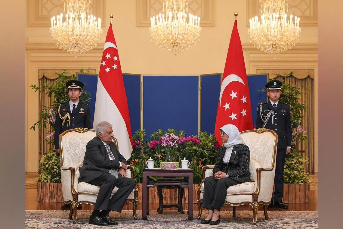 President Halimah Yacob (right) welcomes Sri Lankan President Ranil Wickremesinghe at the Istana on Monday.