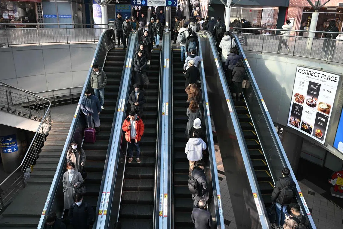 People use escalators outside a train station in Seoul on February 26, 2025. South Korea's birth rate rose last year for the first time in almost a decade, official data showed on February 26, 2025 bucking a trend in a country battling a demographic crisis. (Photo by Jung Yeon-je / AFP)