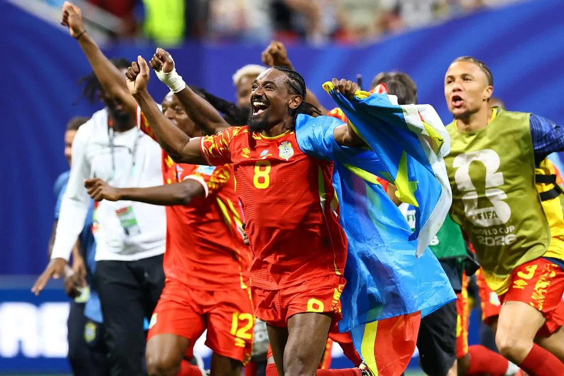 Soccer Football - FIFA World Cup 2026 - Group K - DR Congo v Uzbekistan - Atlanta Stadium, Atlanta, Georgia, U.S. - June 27, 2026 DR Congo's Samuel Moutoussamy celebrates with their national flag after the match as they qualify for the knockout stages of the World Cup REUTERS/Bernadett Szabo