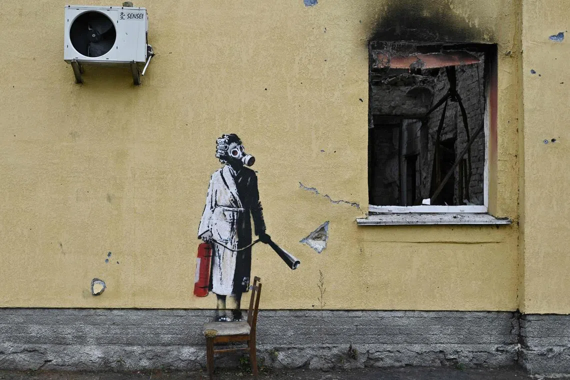 Banksy's portrait of a woman in a gas mask and dressing gown holding a fire extinguisher.