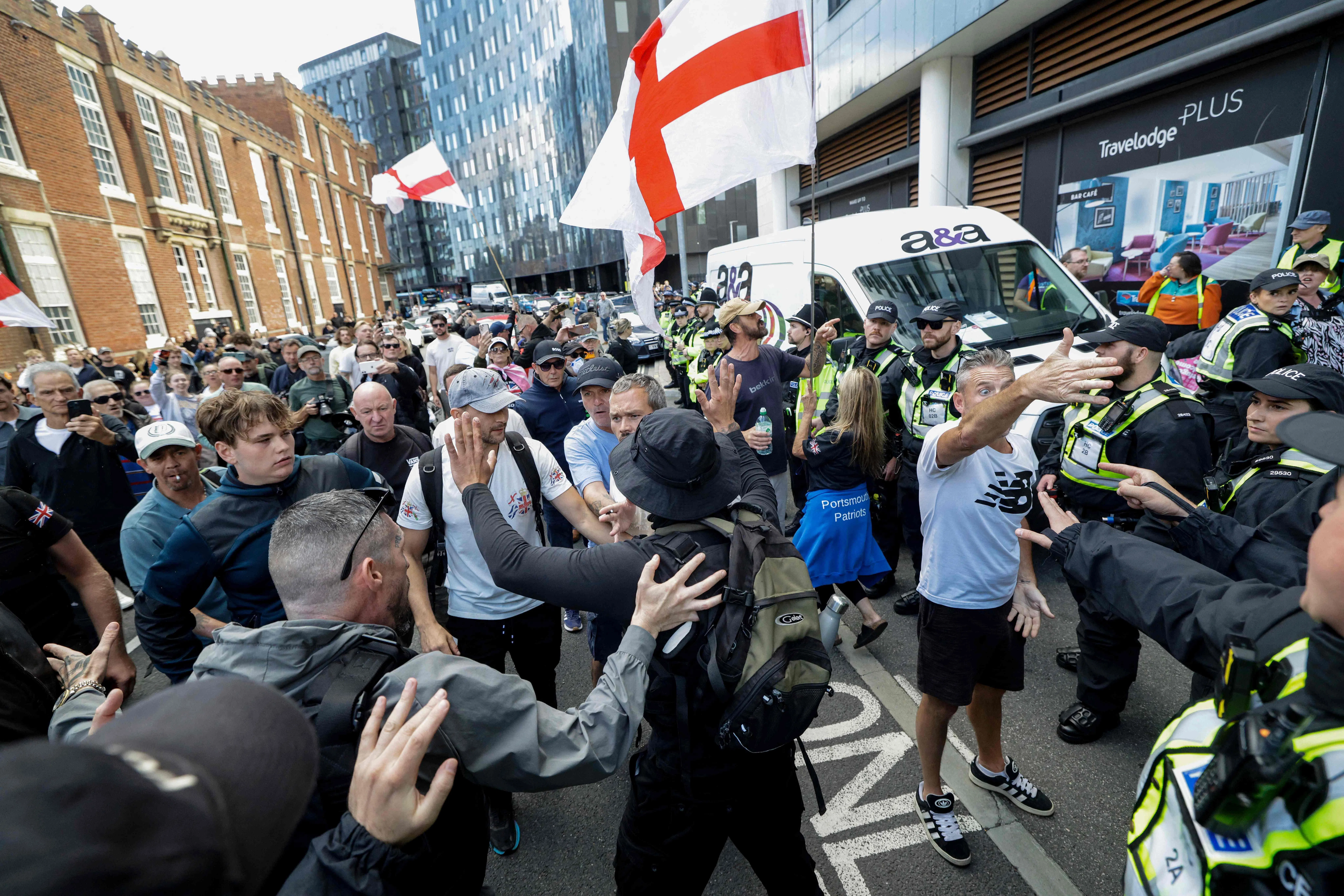Anti-immigration demonstrators (left) confronting police in the English city of Portsmouth on Sept 12.