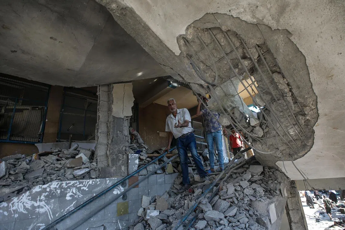 epa11478787 Palestinians inspect a damaged UNRWA school following an Israeli air strike in Al Nuseirat refugee camp, central Gaza Strip, 14 July 2024.  At least 12 people were killed following an Israeli air strike in the camp, according to the Palestinian Ministry of Health. The Israeli military stated on 14 July, that the Israeli Air Force (IAF) struck the area of UNRWA's Abu Oraiban School School building in Nuseirat, claiming that the location served as a 'hideout and operational infrastructure' to direct and carry attacks against Israeli troops operating in the Gaza Strip. More than 38,000 Palestinians and over 1,400 Israelis have been killed, according to the Palestinian Health Ministry and the Israel Defense Forces (IDF), since Hamas militants launched an attack against Israel from the Gaza Strip on 07 October 2023, and the Israeli operations in Gaza and the West Bank which followed it.  EPA-EFE/MOHAMMED SABER