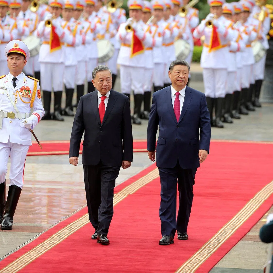Vietnamese General Secretary of the Communist Party To Lam (C) and Chinese President Xi Jinping (R) review the guard of honor at the Presidential Palace in Hanoi, Vietnam 14 April 2025. Xi is on a state visit to Vietnam from 14 to 15 April 2025.     LUONG THAI LINH / /Pool via REUTERS