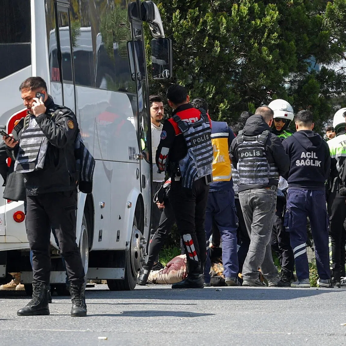 Police stand next to the body of a man believed to have fired shots outside Israel’s consulate in Istanbul.