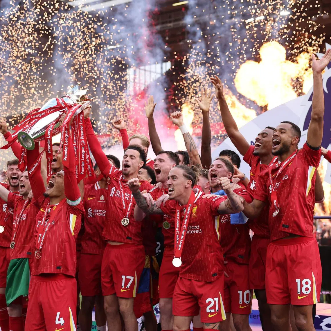 Liverpool's Virgil van Dijk lifts the trophy as he celebrates with teammates after winning the Premier League.