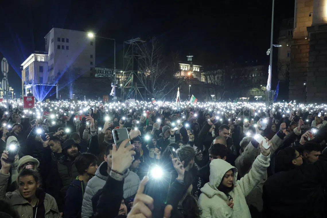 People use the torches on their phones as they demonstrate outside the parliament during an anti-government rally, in Sofia, Bulgaria, December 10, 2025. REUTERS/Stoyan Nenov