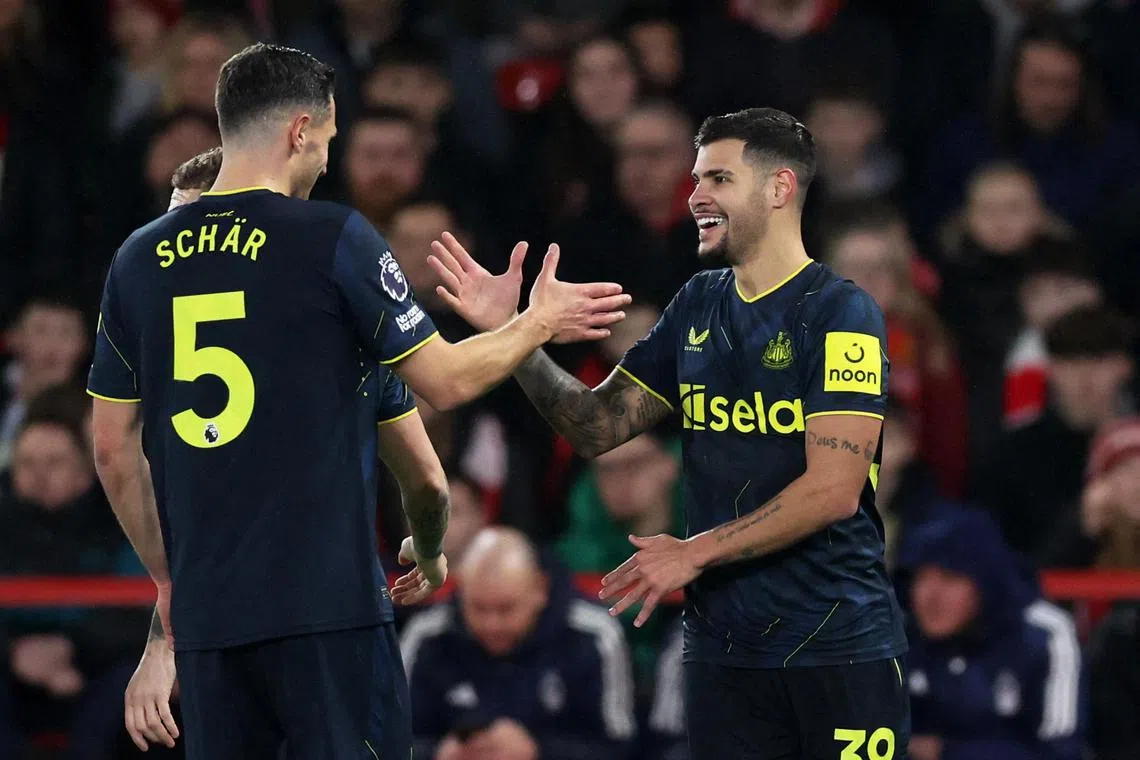 Newcastle United's Bruno Guimaraes celebrates scoring their first goal with Fabian Schar.