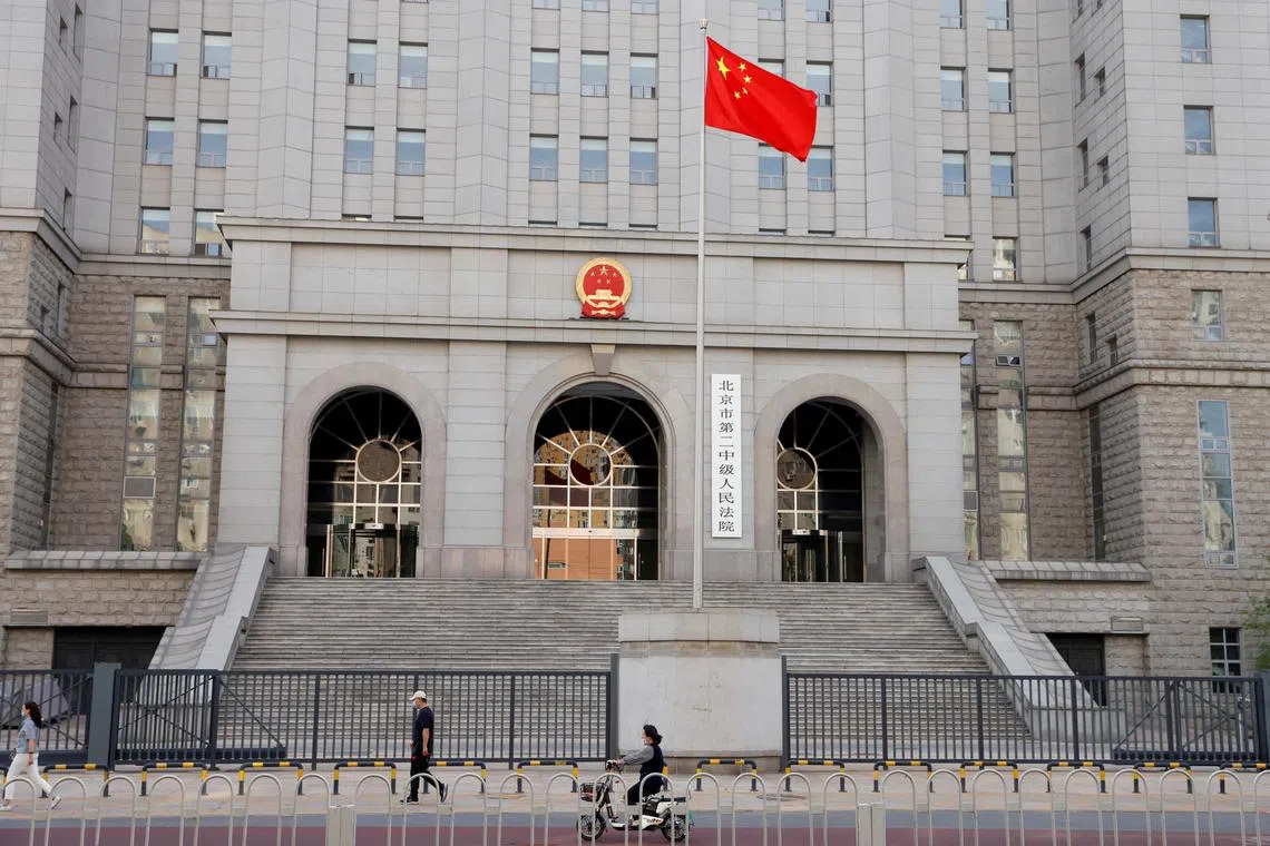 People walk past one of the entrances of Beijing No. 2 Intermediate People's Court where Australian writer Yang Hengjun faced trial on espionage charges.