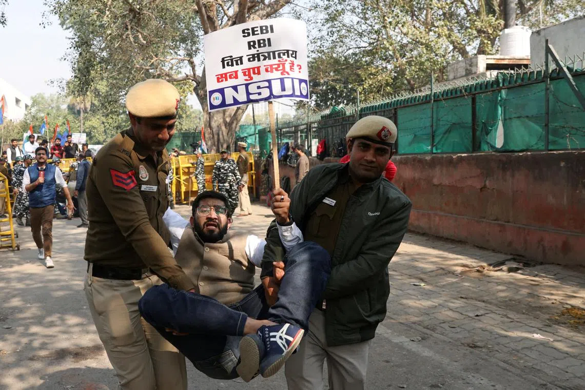 A member of National Students' Union of India, the student wing of India's main opposition Congress party, is detained by police during a protest demanding a probe into Adani Group, in New Delhi, India, Feb 06, 2023. 
