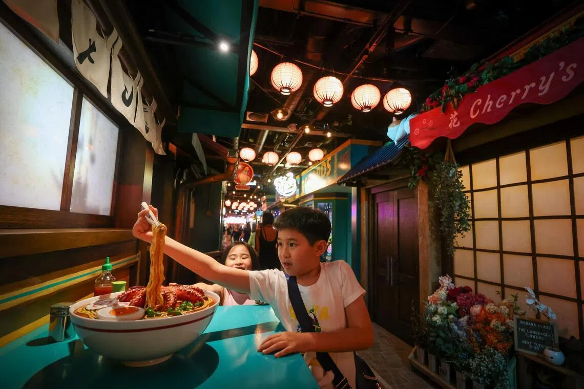 A ramen shop displays an oversized bowl of noodles at San Fransokyo Street.