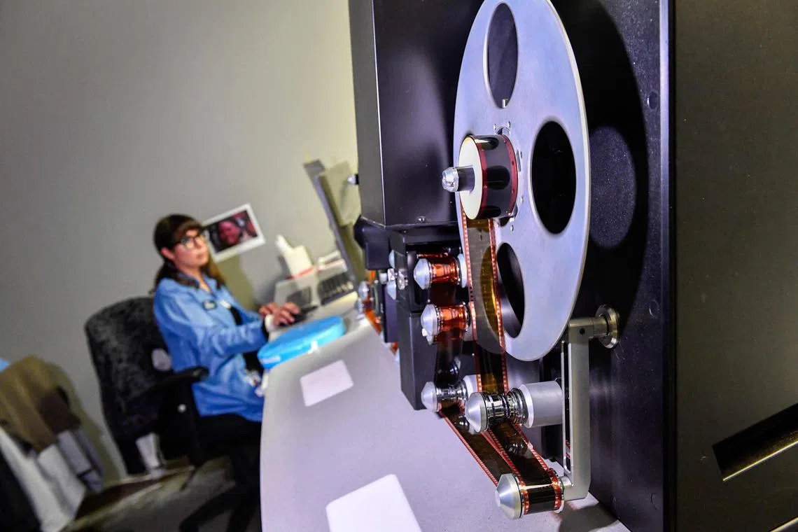 A film specialist digitises film at Pro-Tek Vaults on May 7, 2024 in Burbank, California. Reels of film and the Hollywood stars who fill them share one common enemy: ageing.
But while an actor can go under the knife or get a bit of filler in an effort to stay young, it's a one-way street for film, which eventually starts to break down into its original -- rather prosaic -- ingredients.
"Film base is actually wood pulp and acetic acid in its simplest form," says Tim Knapp of California-based film preservation specialists Pro-Tek Vaults. (Photo by VALERIE MACON / AFP)