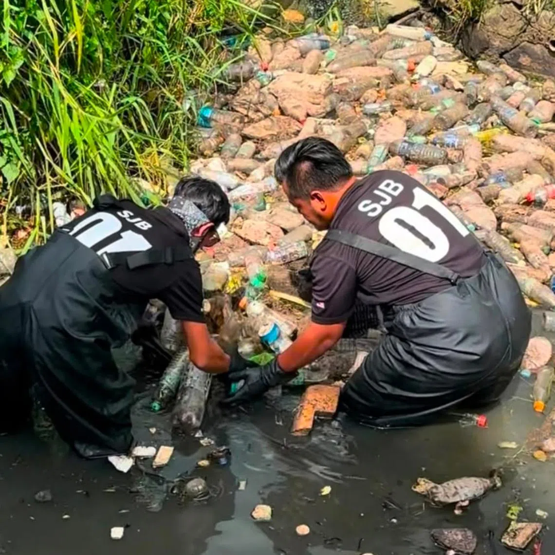 Members of Skuad Johor Bersih cleaning up a rubbish-clogged river in Johor Bahru in 2025.