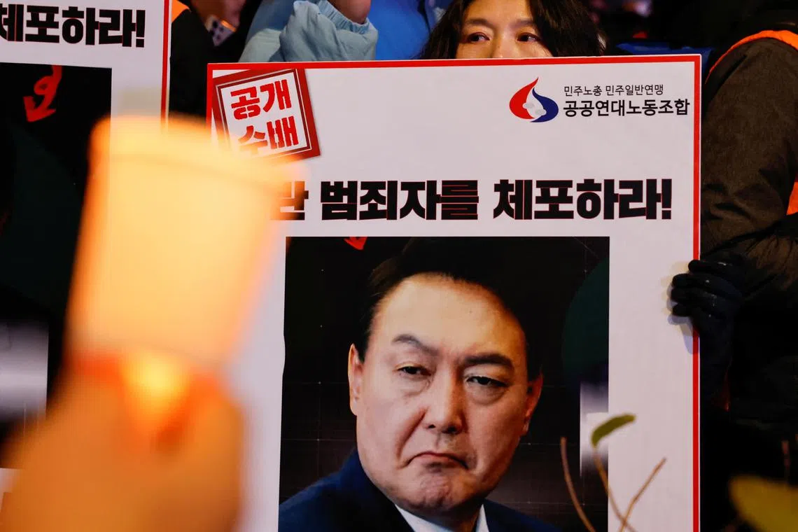 Protesters hold placards during a candlelight vigil to condemn South Korean President Yoon Suk Yeol's surprise declarations of the failed martial law and to call for his resignation in Seoul, South Korea, December 5, 2024. REUTERS/Kim Kyung-Hoon